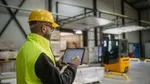 Due uomini in camice bianco ed elmetti di protezione in un impianto industriale.